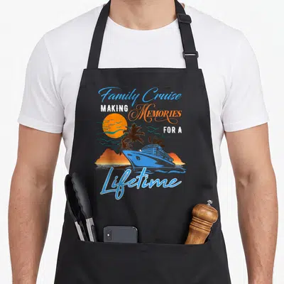 Family cruise memory apron - Blue cruise ship and palm tree sunset with making memories for a lifetime text — shown on a black cotton canvas apron against a white background