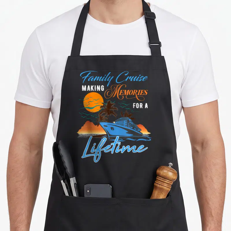 Family cruise memory apron - Blue cruise ship and palm tree sunset with making memories for a lifetime text — shown on a black cotton canvas apron against a white background