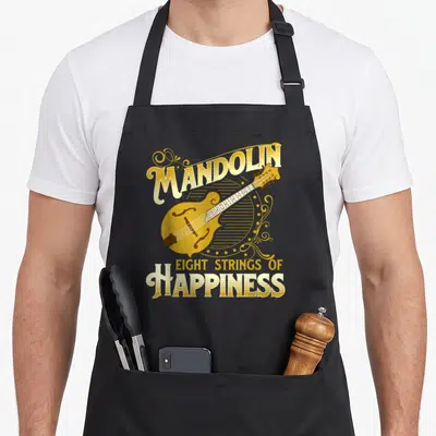 Mandolin string apron - Yellow mandolin illustration with arched text and decorative swirls on grey background — shown on a black cotton canvas apron against a white background