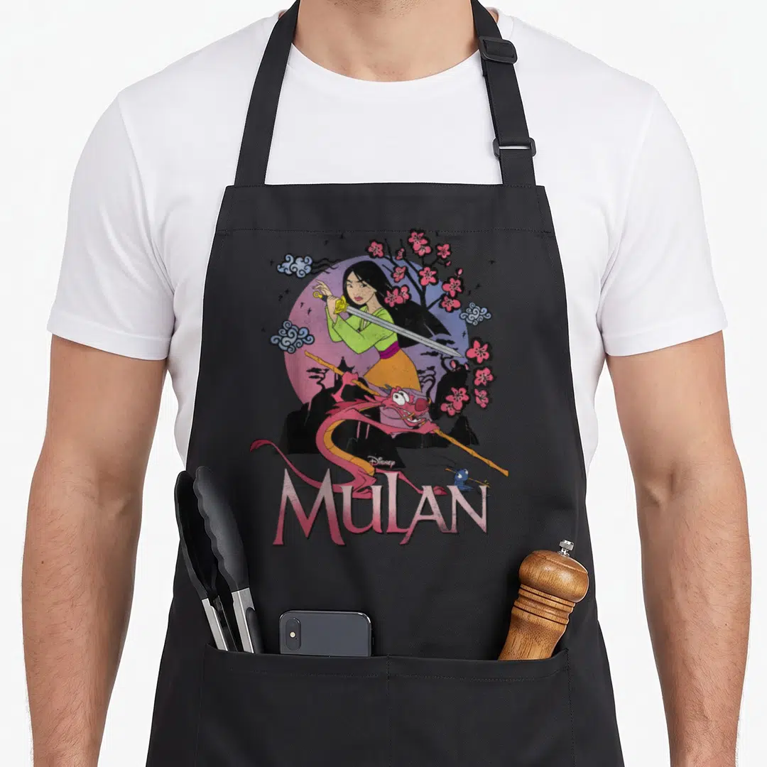 Stance warrior apron - Mulan holding sword with Mushu Cri-Kee pink sun cherry blossoms cartoon art — shown on a black cotton canvas apron against a white background