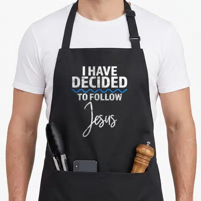 Believer baptism apron - Stacked white text I HAVE DECIDED TO FOLLOW Jesus with blue wavy line — shown on a black cotton canvas apron against a white background