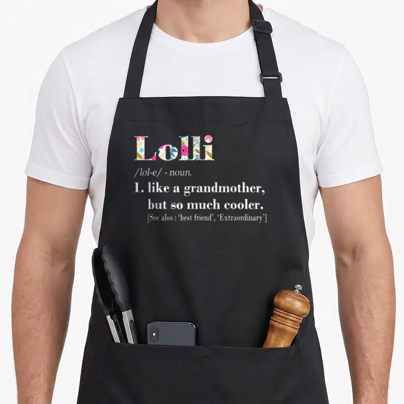 But grandmother apron - Lolli dictionary definition text with floral filled letters and cool grandmother quote — shown on a black cotton canvas apron against a white background