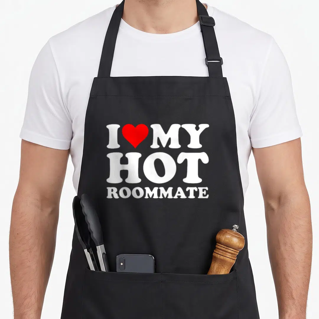Hot roommate apron - White text I red heart MY HOT ROOMMATE stacked vertically — shown on a black cotton canvas apron against a white background