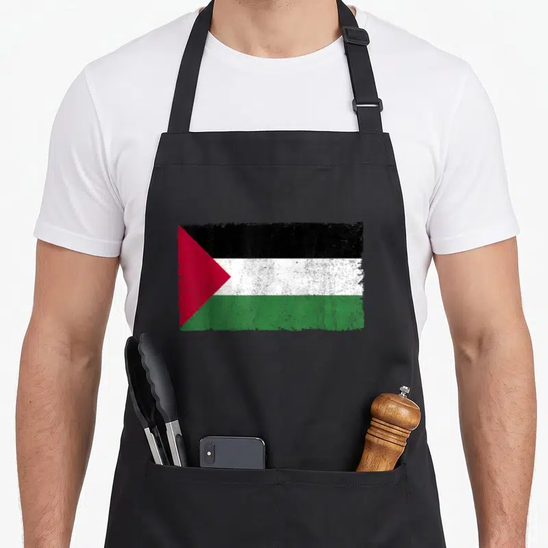 Proud palestinian apron - Distressed rectangular flag with black white green red stripes and red triangle on left side — shown on a black cotton canvas apron against a white background