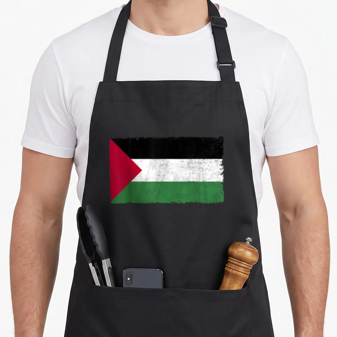 Proud palestinian apron - Distressed rectangular flag with black white green red stripes and red triangle on left side — shown on a black cotton canvas apron against a white background