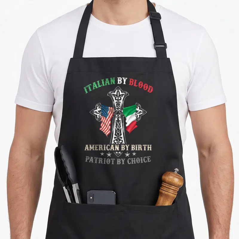 Birth italian apron - Ornate white cross with draped US and Italian flags and heritage text — shown on a black cotton canvas apron against a white background