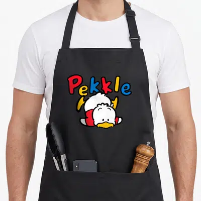 Pekkle general apron - Arched Pekkle text above a white duck character lying on its stomach in red yellow blue and white — shown on a black cotton canvas apron against a white background