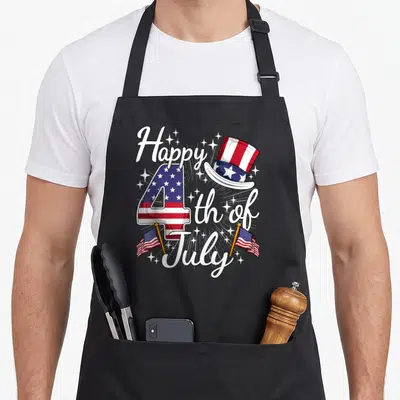 Cute patriotic 4th of july apron - Number 4 filled with red white and blue flag pattern, top hat, and script text — shown on a black cotton canvas apron against a white background