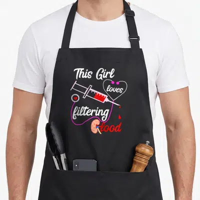 Dialysis nephrology nurse apron - This Girl loves filtering Blood text with pink syringe, red heart, and kidney organ — shown on a black cotton canvas apron against a white background