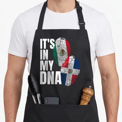 Dominican mexican apron - IT'S IN MY DNA text next to two fingerprints filled with Mexican and Dominican flag colors — shown on a black cotton canvas apron against a white background