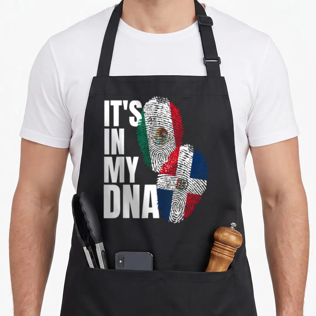 Dominican mexican apron - IT'S IN MY DNA text next to two fingerprints filled with Mexican and Dominican flag colors — shown on a black cotton canvas apron against a white background