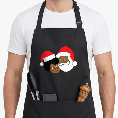 Loving mrs apron - Cartoon Santa and Mrs. Claus heads leaning together wearing red hats with brown skin tones — shown on a black cotton canvas apron against a white background