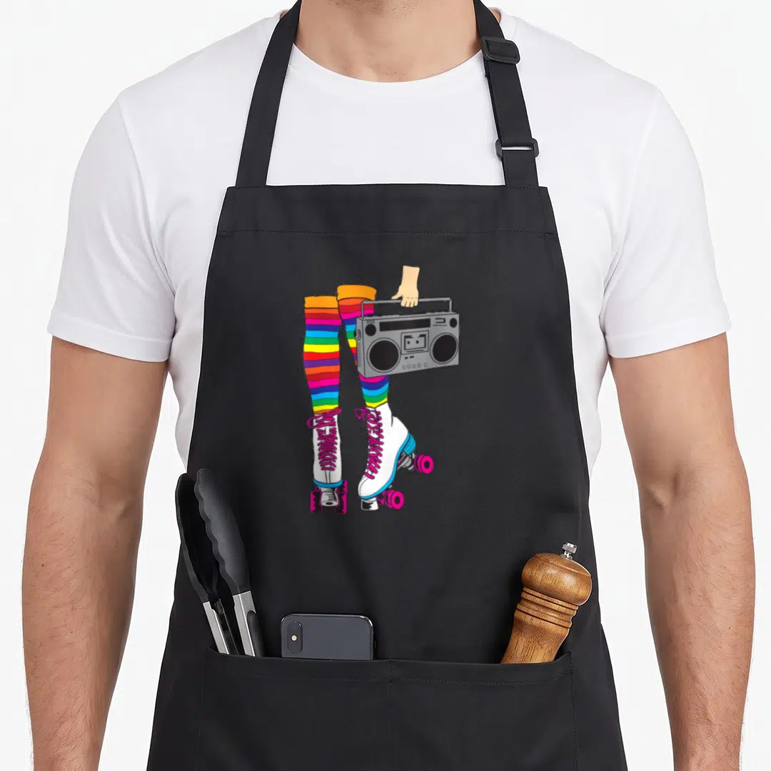 Disco 80s apron - Cartoon legs in rainbow striped socks holding grey boombox with white roller skates — shown on a black cotton canvas apron against a white background