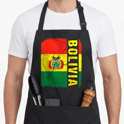 Bolivian pride apron - Distressed Bolivian flag with vertical BOLIVIA text and coat of arms on red yellow green stripes — shown on a black cotton canvas apron against a white background