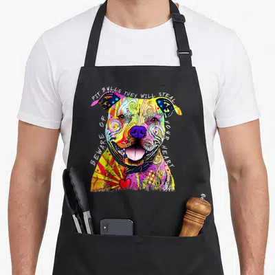 Pit dean russo aprons - Multicolored watercolor pit bull head with arching text and small red heart at bottom — shown on a black cotton canvas apron against a white background