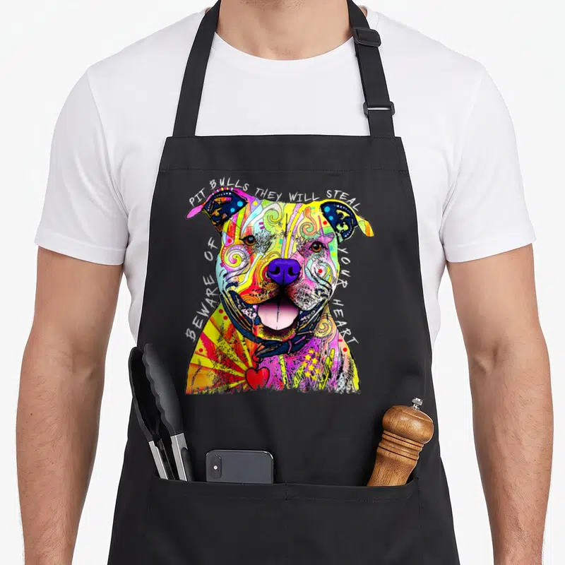 Pit dean russo aprons - Multicolored watercolor pit bull head with arching text and small red heart at bottom — shown on a black cotton canvas apron against a white background