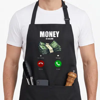 Calling money apron - MONEY IS CALLING text, cash stack, red decline green accept buttons — shown on a black cotton canvas apron against a white background