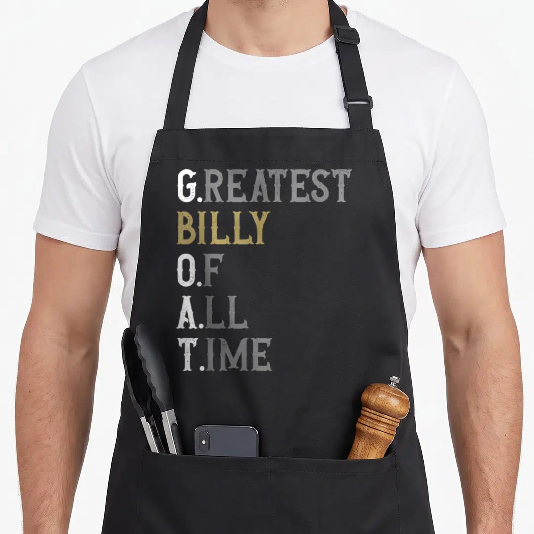 Greatest billy goat apron - Stacked G. BILLY O. A. T. text in white and gold on black background — shown on a black cotton canvas apron against a white background