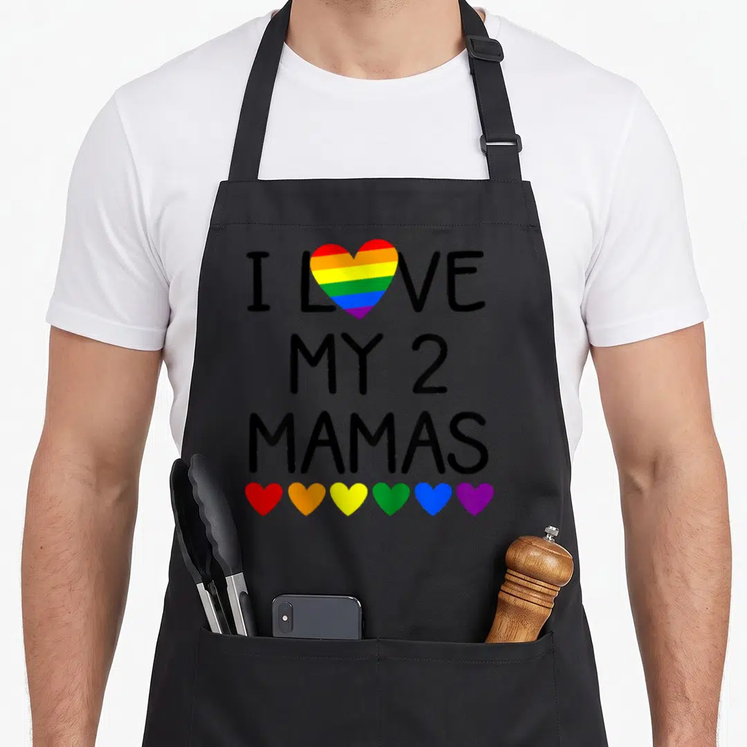 Newborn toddler mom apron - I LOVE MY 2 MAMAS text with rainbow heart and six small colorful hearts below — shown on a black cotton canvas apron against a white background