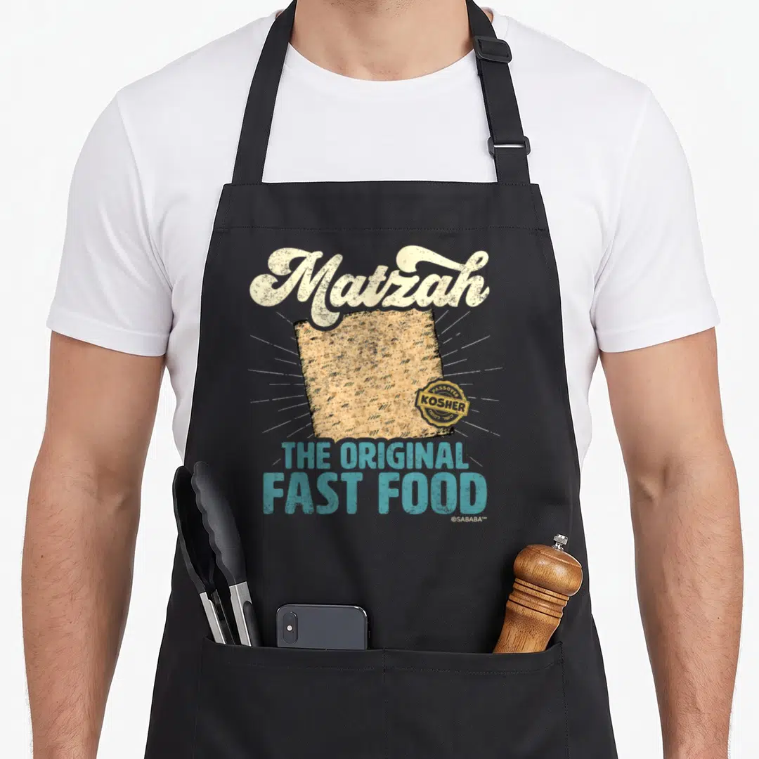 Matzah passover apron - Distressed Matzah text above a cracker with Kosher seal and original fast food slogan — shown on a black cotton canvas apron against a white background