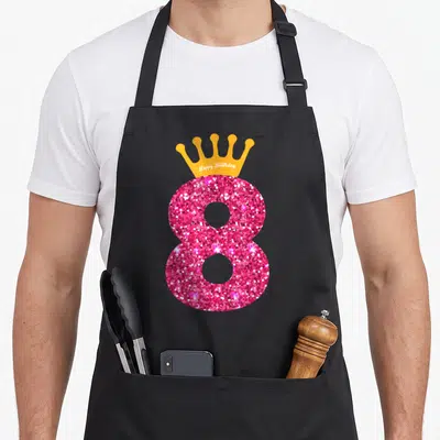 8th bday birthday apron - Pink glittery number 8 with orange crown containing white Happy Birthday text — shown on a black cotton canvas apron against a white background