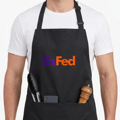 Retired extrovert apron - ExFed text in purple and orange block typography on black fabric — shown on a black cotton canvas apron against a white background