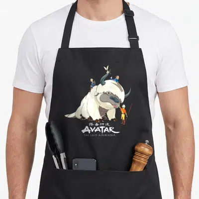 Appa anime birthday apron - Appa with Aang, Sokka, Momo and AVATAR logo in white grey yellow blue — shown on a black cotton canvas apron against a white background