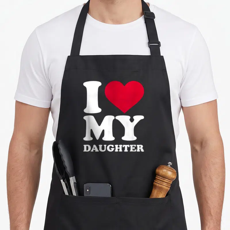 Cute mom daughter aprons - White I and MY DAUGHTER text with a red heart symbol on a black background — shown on a black cotton canvas apron against a white background