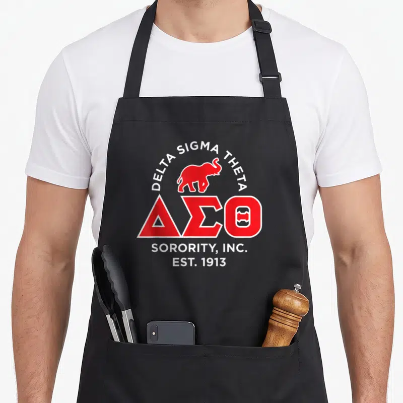 Theta paraphernalia hbcu sorority apron - Red elephant and white Delta Sigma Theta text on apron front — shown on a black cotton canvas apron against a white background