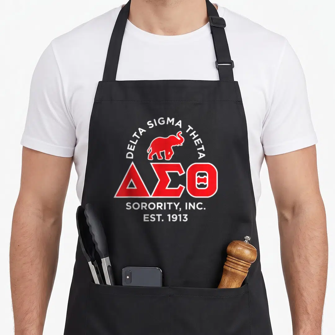 Theta paraphernalia hbcu sorority apron - Red elephant and white Delta Sigma Theta text on apron front — shown on a black cotton canvas apron against a white background