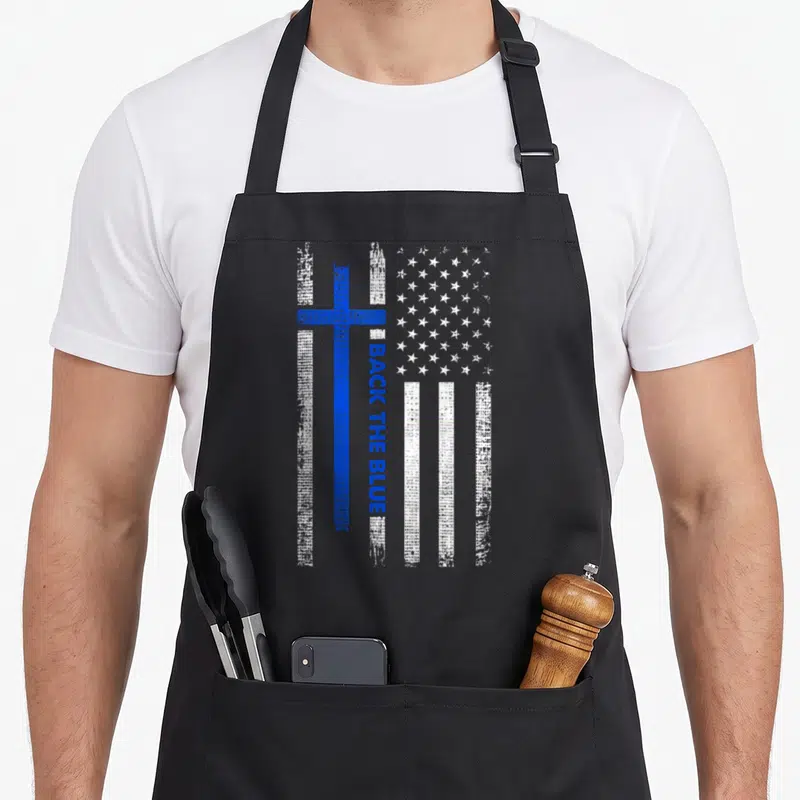 Blue cross back apron - Distressed blue cross over white stripes with vertical BACK THE BLUE text and field of white — shown on a black cotton canvas apron against a white background