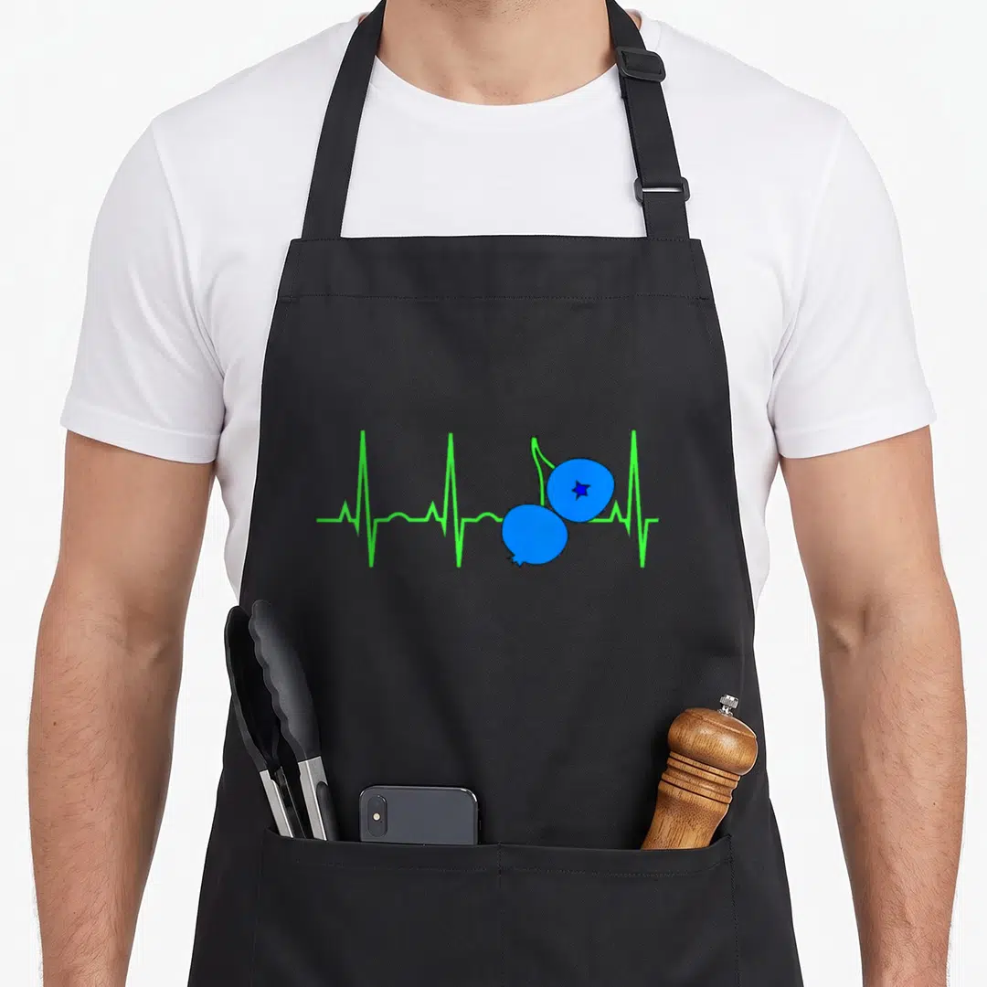 Heartbeat blueberries apron - Two blue berries on stem over green EKG line cartoon graphic — shown on a black cotton canvas apron against a white background