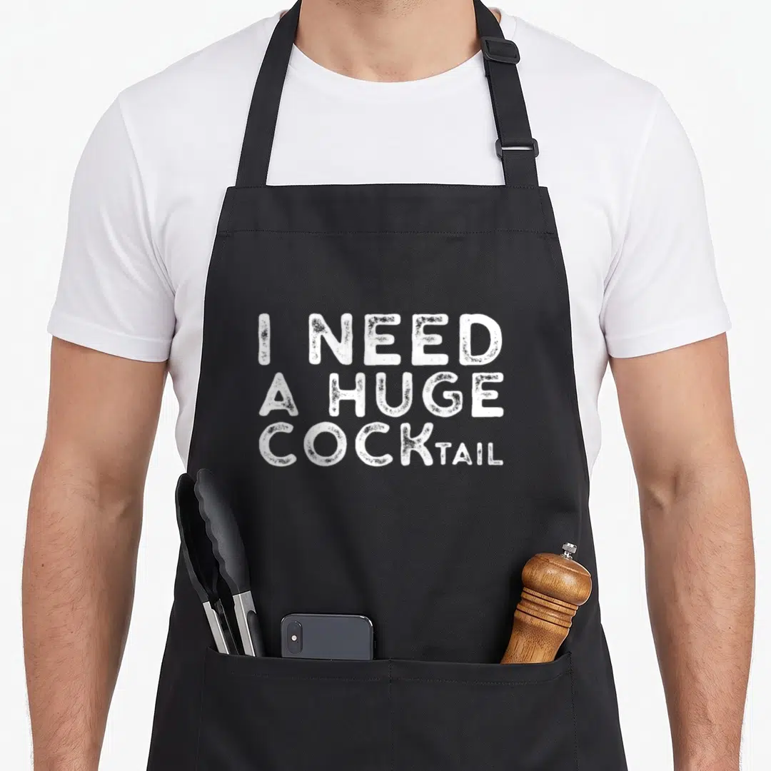Drinking cocktail apron - White stacked text reading I NEED A HUGE COCKTAIL in distressed font — shown on a black cotton canvas apron against a white background