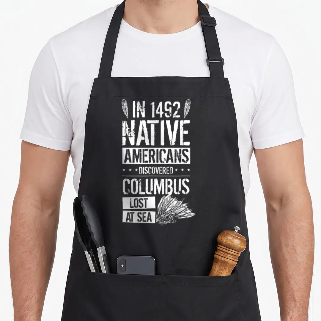 Discovered native american apron - White stacked text reading IN 1492 NATIVE AMERICANS DISCOVERED COLUMBUS LOST AT SEA — shown on a black cotton canvas apron against a white background