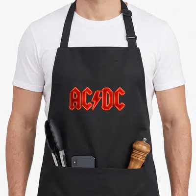 Electric ac dc apron - Red AC/DC logo with lightning bolt in bold angular font — shown on a black cotton canvas apron against a white background