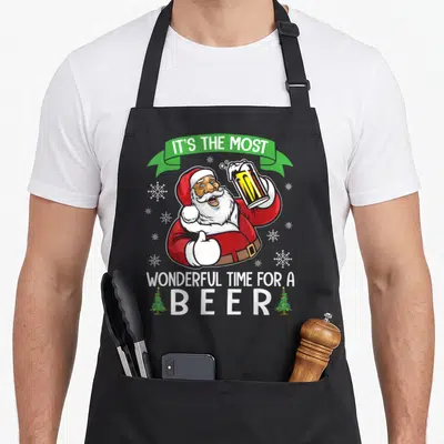 Drinking santa apron - Santa thumbs up holding beer glass with IT'S THE MOST WONDERFUL TIME FOR A BEER text — shown on a black cotton canvas apron against a white background