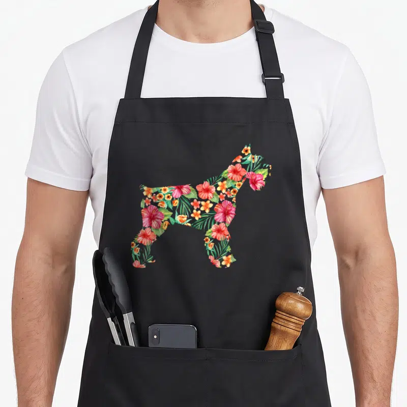Flower schnauzer apron - Schnauzer silhouette filled with red orange and green tropical hibiscus flowers and leaves — shown on a black cotton canvas apron against a white background