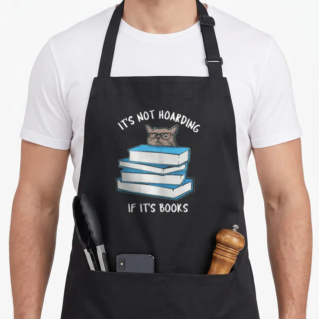 Hoarding russian aprons - Cartoon cat head peeking over four blue and white books with white text — shown on a black cotton canvas apron against a white background