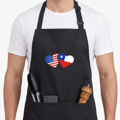 Chile chilean american flag apron - Two overlapping hearts filled with USA and Chile flag patterns in red, white — shown on a black cotton canvas apron against a white background