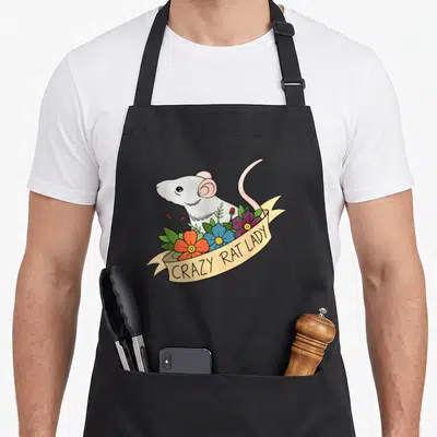 Flower pet apron - Cartoon rat behind orange blue purple flowers with CRAZY RAT LADY banner — shown on a black cotton canvas apron against a white background