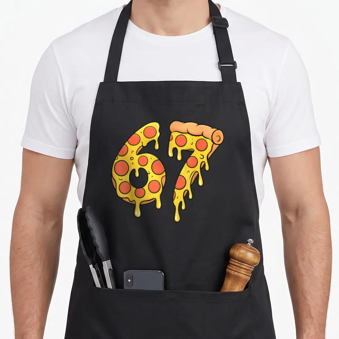 Meme pizza apron - Number 67 shaped like melting pepperoni pizza slices with yellow cheese drips — shown on a black cotton canvas apron against a white background
