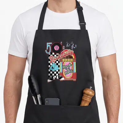 Rockabilly 1950s apron - Cartoon jukebox with vinyl record, blue skirt, and black sneakers on checkerboard — shown on a black cotton canvas apron against a white background