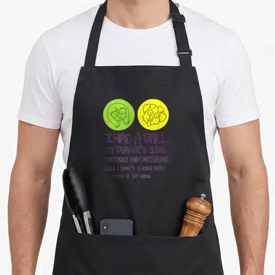 Ball birthday apron - Child drawing of girl and dog in green and yellow circles with purple birthday text — shown on a black cotton canvas apron against a white background