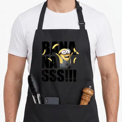 Goe general apron - Centered Minion character with four bananas and stacked black BANA NA SSS text — shown on a black cotton canvas apron against a white background