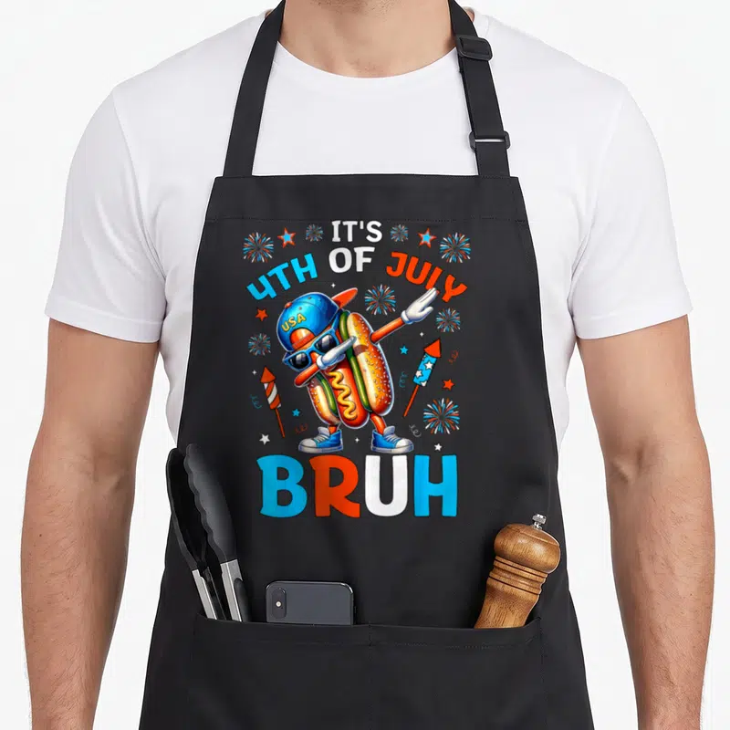 Hotdog 4th of july apron - Dabbing hot dog wearing USA cap and sunglasses with IT'S 4TH OF JULY USA BRUH text — shown on a black cotton canvas apron against a white background