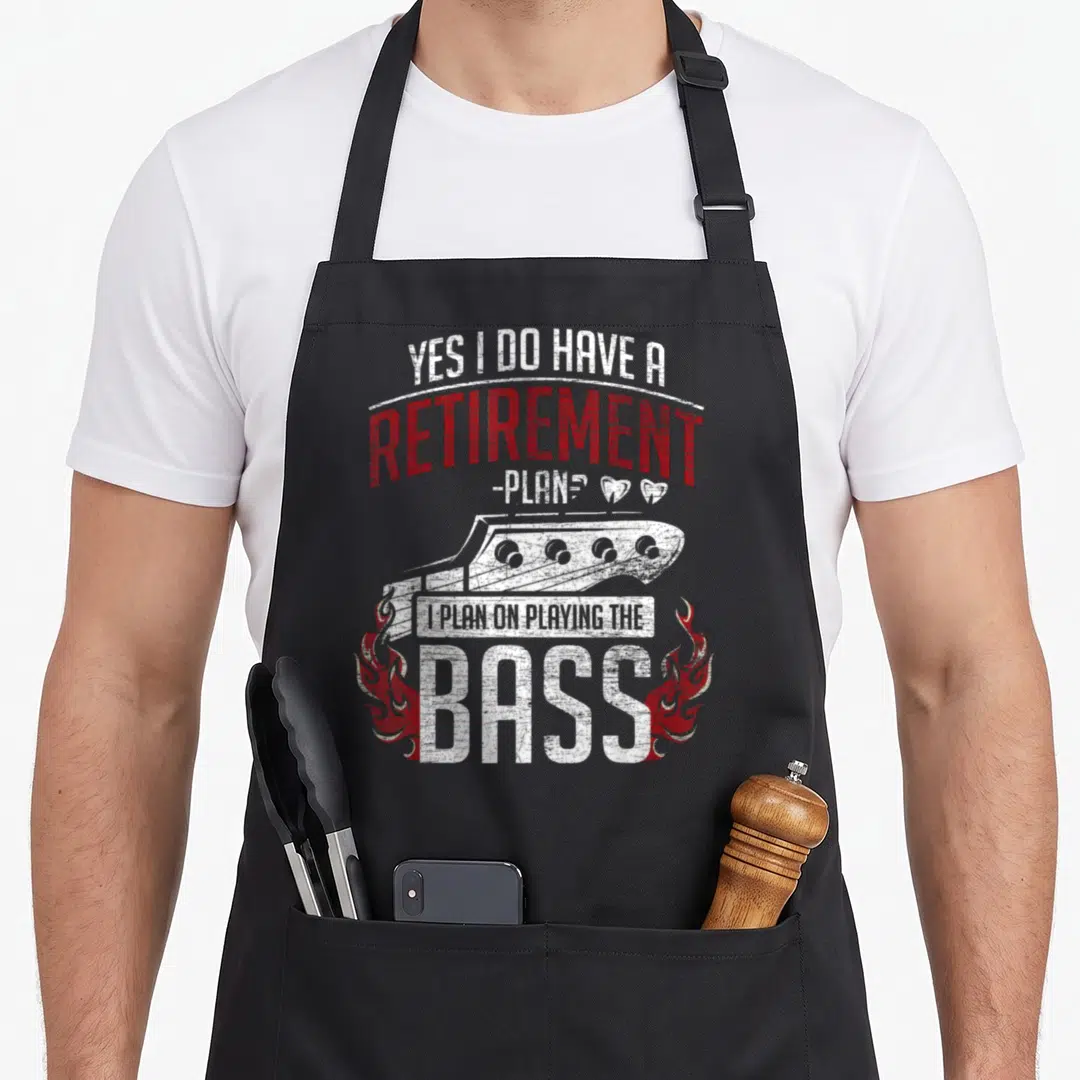 Bassist retirement apron - Distressed bass guitar headstock with stacked text YES I DO HAVE A RETIREMENT I PLAN — shown on a black cotton canvas apron against a white background