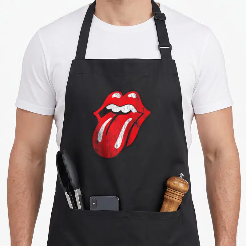 Baseball rolling stones apron - Distressed red open mouth with protruding tongue and white teeth outlined in black — shown on a black cotton canvas apron against a white background
