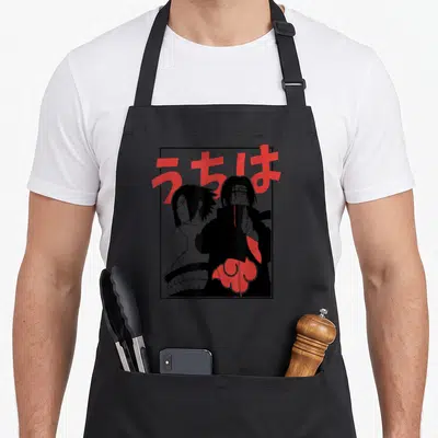 Frame general apron - Two cartoon characters in black border with red Japanese text Uchiha — shown on a black cotton canvas apron against a white background