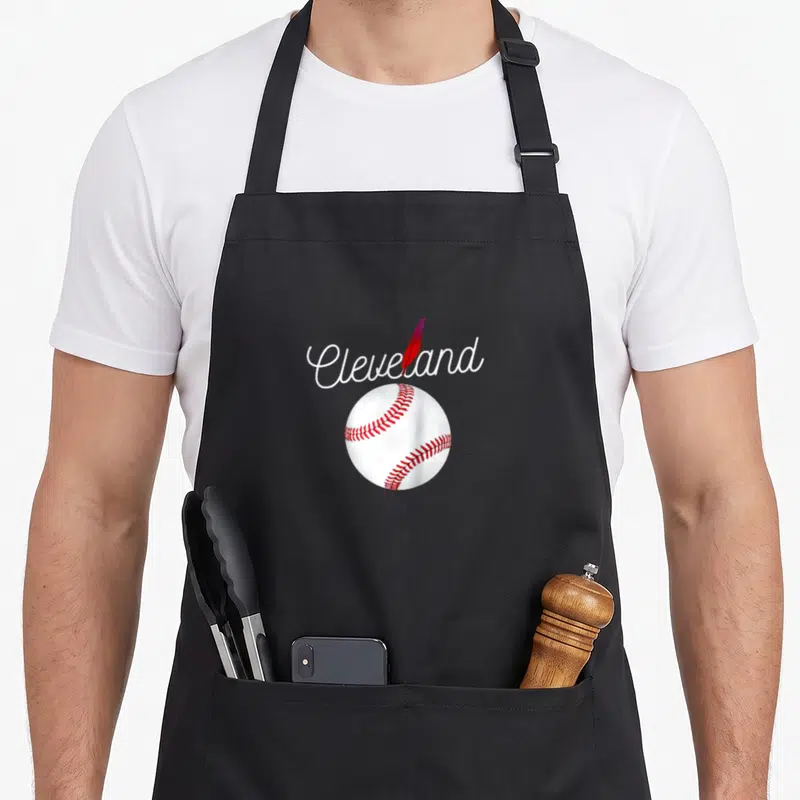 Tribe baseball apron - Cleveland script text above white baseball with red stitches and diagonal red feather — shown on a black cotton canvas apron against a white background