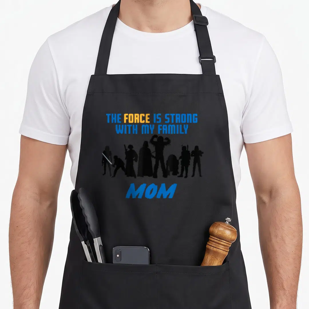 Force family aprons - Blue and orange text above black Star Wars character silhouettes with MOM below — shown on a black cotton canvas apron against a white background